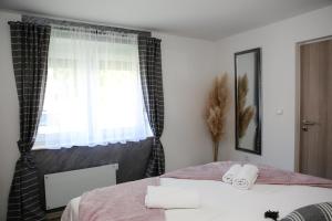 1 dormitorio con 1 cama con 2 toallas en Apartman Grey, en Jastrebarsko