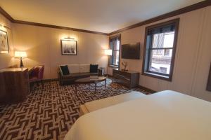a hotel room with a bed and a couch at Iroquois New York Times Square in New York