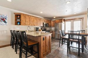 a kitchen with wooden cabinets and a table and chairs at Moosehollow Condos in Eden
