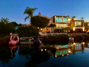 a house with a boat in the water at night at Chic Venice Beach Bungalow Steps from the Canals & Beach in Los Angeles