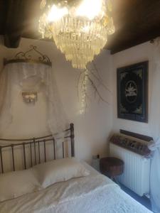 1 dormitorio con cama y lámpara de araña en Feggaropetra Inn Magic Mountain House, en Palaios Panteleimon