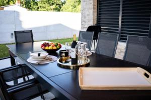 Villa Istra Relax Smaragd في Rebići: طاولة سوداء عليها صحن فاكهة