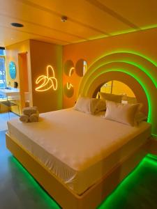 a bedroom with a large bed with green lights at Andar de Cima Suítes in São Paulo