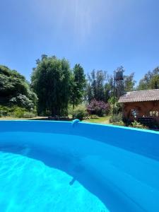 una piscina de agua azul en un patio en Posada de la Rosarito en Brandsen