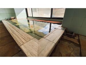 drewniana ławka w pokoju z oknem w obiekcie Hotel & Onsen 2307 Shigakogen - Vacation STAY 72767v w mieście Shiga Kōgen