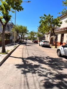 une rue avec des voitures garées sur le côté de la route dans l'établissement Apartamentos a 50 mts de Rambla de Mercedes, à Mercedes