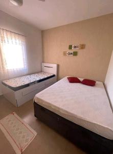 a bedroom with two beds and a window at Praia Martin de Sá SP. in Caraguatatuba