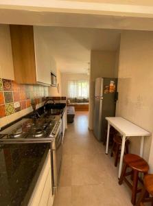 a kitchen with a stove and a refrigerator at Praia Martin de Sá SP. in Caraguatatuba