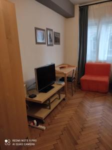 Habitación con escritorio, TV y silla. en Coronation Apartment en Bratislava