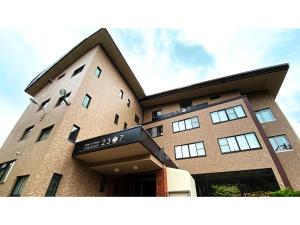 a large brick building with a sign on it at Hotel & Onsen 2307 Shigakogen - Vacation STAY 68476v in Shiga Kogen