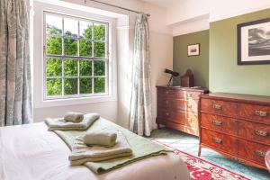 um quarto com uma cama, uma janela e uma cómoda em Sophisticated & Secluded 3BD in Forest of Dean! em Lydbrook