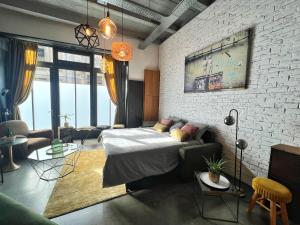 a living room with a bed and a brick wall at Le Gambrinus - Loft Rochelais in La Rochelle