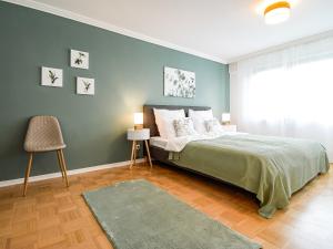 a bedroom with a bed and a blue wall at SCANDIC-Apartment, Balkony, Free Coffee, 80m2 in Pforzheim