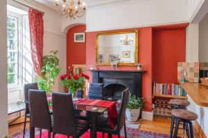 une salle à manger avec une cheminée et un miroir dans l'établissement Sophisticated & Secluded 3BD in Forest of Dean!, à Lydbrook