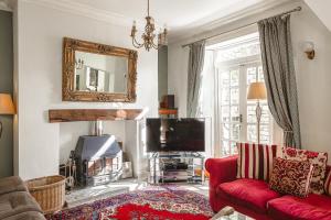 - un salon avec un canapé rouge et une télévision dans l'établissement Sophisticated & Secluded 3BD in Forest of Dean!, à Lydbrook