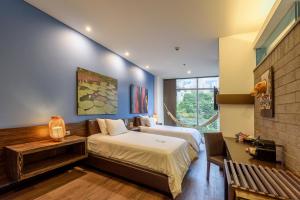 Diez Hotel Categoría Colombia في ميديلين: غرفة نوم بسريرين في غرفة