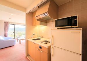 a kitchen with a refrigerator and a microwave at Kamogawa Grand Tower - Vacation STAY 53387v in Kamogawa