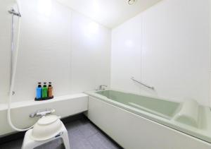 a bathroom with a tub and a toilet and a sink at Kamogawa Grand Tower - Vacation STAY 53387v in Kamogawa