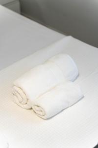 エギオにあるAngelica apartmentの白いタオルの積み重ねがベッドに座っている