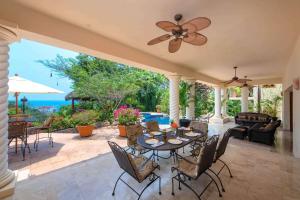 a patio with a table and chairs and the ocean at Sea Treasure Villa in Puerto Vallarta