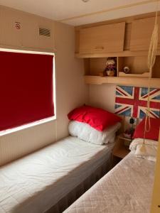 um pequeno quarto com 2 camas e uma janela em Coastal Getaway, camber sands em Camber