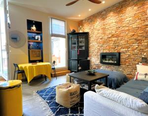 a living room with a couch and a brick wall at Un écrin à Cassis in Cassis