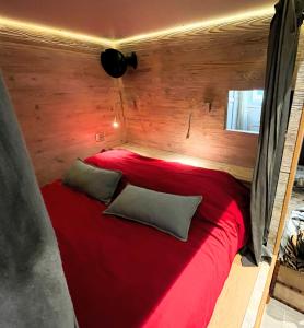 a red bed with two pillows in a room at Un écrin à Cassis in Cassis