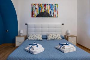a bedroom with a blue bed with towels on it at Casa Adalù in Naples