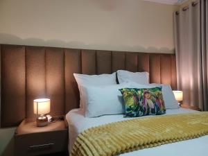 a bed with two lamps and two pillows on it at Sindy's Chalets in Margate +19 photos