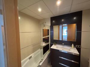 ein Badezimmer mit einem Waschbecken, einer Badewanne und einem Spiegel in der Unterkunft Casa Los Caños de Alhama in Alhama de Almería