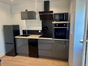 a kitchen with a stove and a microwave at Maison cocooning in Châteauroux