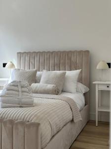 een witte slaapkamer met een groot bed met witte kussens bij Entire rental unit hosted by Lux Living in Oxford