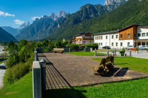 a bench in a park with mountains in the background at Hotel Serena - Tre Cime Views in Auronzo di Cadore