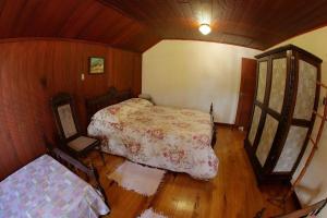 坎普阿萊格里的住宿－Hospedaria 71，铺有木地板的客房内设有一间卧室和一张床。