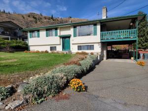 a white house with a porch and a balcony at Charming - 2 bedrooms basemnt, 1 full bath & rec room in Kamloops