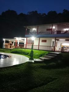 une maison la nuit avec un étang devant elle dans l'établissement Casa Campestre Privada El Reposo con piscina y WIFI, à La Vega