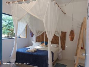 a bedroom with a bed with a canopy at Res. Orion Praia do Espelho in Praia do Espelho