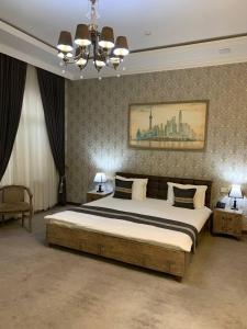 a bedroom with a large bed and a chandelier at Archie Family Hotel in Tashkent