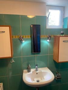 een badkamer met een wastafel en een spiegel aan de muur bij Monteur Gäste Zimmer Stadt Hafen in Husum