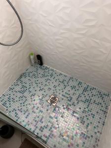 uma casa de banho com piso em azulejo e um chuveiro. em Maison avec jardin em Viry-Châtillon