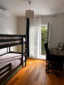 a bedroom with bunk beds and a desk and a window at Maison avec jardin in Viry-Châtillon