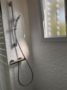 uma cabeça de chuveiro numa casa de banho com uma janela em Maison avec jardin em Viry-Châtillon