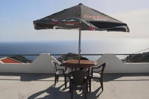 a table and chairs under an umbrella on a roof at Fifty´s House in Ribeira Brava