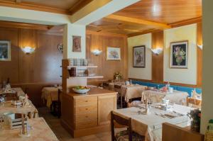 アウロンツォ・ディ・カドーレにあるHotel Serena - Tre Cime Viewsのダイニングルーム(テーブル、椅子付)