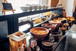 a buffet line with bowls of food on a counter at Remota in Puerto Natales