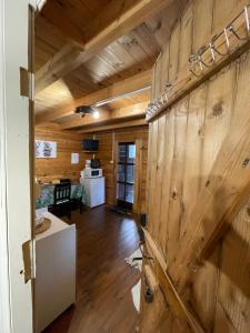 a living room with wooden walls and wooden floors at LES CHALETS DE VANESS' le Mahé in Digoin
