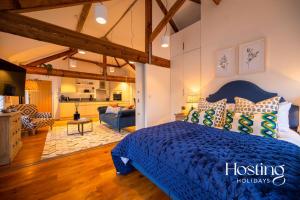 a bedroom with a blue bed and a living room at The Penthouse, Henley-On-Thames in Henley on Thames