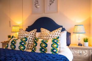 a bedroom with a blue bed with pillows on it at The Penthouse, Henley-On-Thames in Henley on Thames