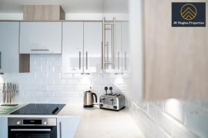 a white kitchen with a toaster on a counter at Exclusive Apartment by AV Hughes Properties Short Lets & Serviced Accommodation Milton Keynes with Fast Wi-Fi in Milton Keynes