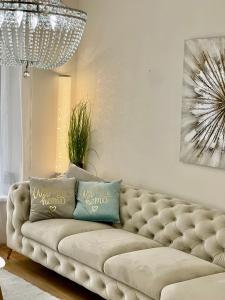 a living room with a couch and a chandelier at Apartment Puma v centre Piešťan in Piešťany